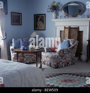 Floral Sessel und runder Tisch Kamin im blauen Land Schlafzimmer Stockfoto