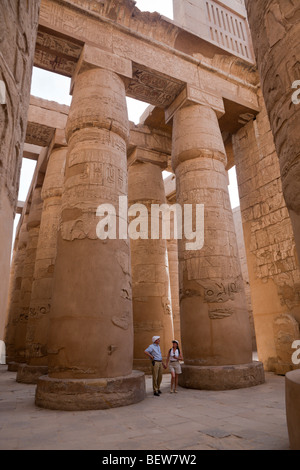 Touristen zwischen Säulen der großen Säulenhalle am Karnak-Tempel, Luxor, Ägypten Stockfoto