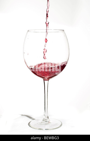 Wein in ein Glas Wein vor weißem Hintergrund gegossen Stockfoto