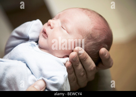 Mann hält ein schlafendes Baby in seinen Händen, Nahaufnahme Stockfoto