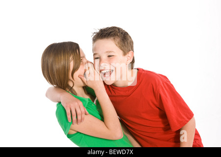 Mädchen etwas ein Junge ins Ohr flüstern Stockfoto