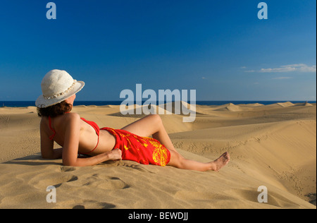 Frau liegt auf einer Düne mit Blick auf das Meer, Maspalomas, Gran Canaria, Spanien, Seitenansicht Stockfoto