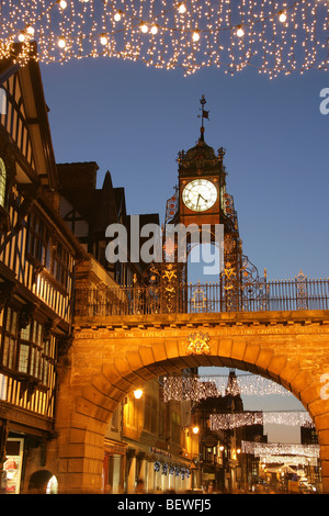 Von Chester, England. Nachtansicht des Eastgate und Eastgate Clock mit Weihnachten Straßenlaternen und Dekorationen. Stockfoto