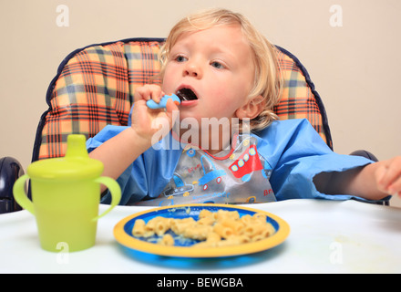 Kleinkind im Hochstuhl Pasta Essen Stockfoto