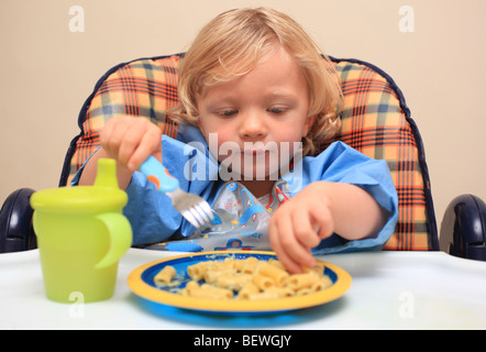 Kleinkind im Hochstuhl Pasta Essen Stockfoto