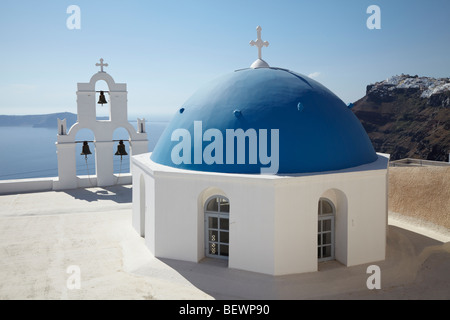 Griechische weiße Kirche mit Glockenturm und blauen Kuppel, mit Blick auf das Meer, Santorini, Kykladen, Griechenland. Stockfoto