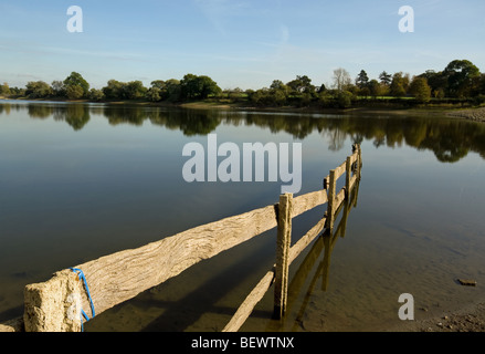 Eine Landschaft am Welford Reservoir zeigt einen alten Zaun ins Wasser gebaut. Stockfoto