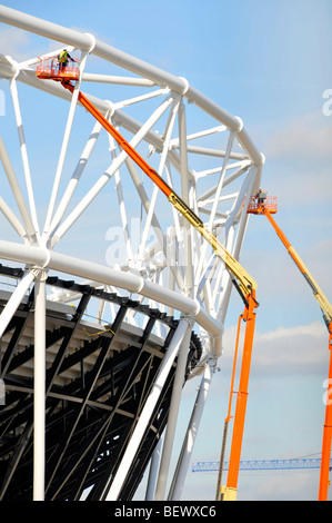 Männer arbeiten von Hubarbeitsbühnen Hebezeuge auf das Stahlgerüst der wichtigsten 2012 Olympiastadion Stockfoto