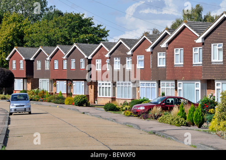 Reihe von Häusern in Wohnstraße von Immobilien-Gehäuse Grundstücksentwicklung identische Einfamilienhäuser individuelle Gärten & Auto Auffahrt England GB Stockfoto