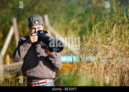 Junge Naturfotograf fotografieren mit Teleobjektiv Stockfoto