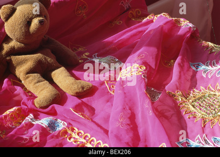 Nahaufnahme von Teddy-Bär auf Gold bestickt rosa indischen Seiden-Bettdecke Stockfoto