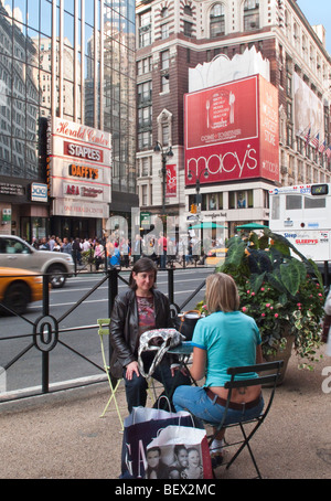 Zwei Frauen, die eine Pause vom Einkaufen außerhalb Kaufhaus Macy's in New York City Stockfoto