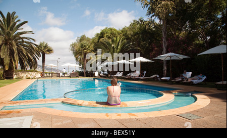 Eine Frau liest ein Buch in den Swimmingpool des Hotels Quinta da Bela Vista Hotel, Funchal, Madeira Stockfoto