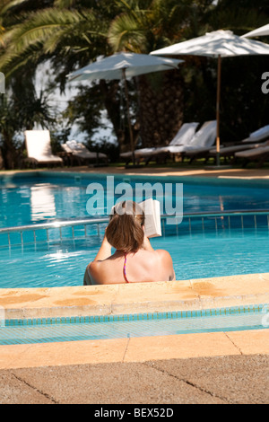 Eine Frau liest ein Buch in den Swimmingpool des Hotels Quinta da Bela Vista Funchal Madeira Stockfoto