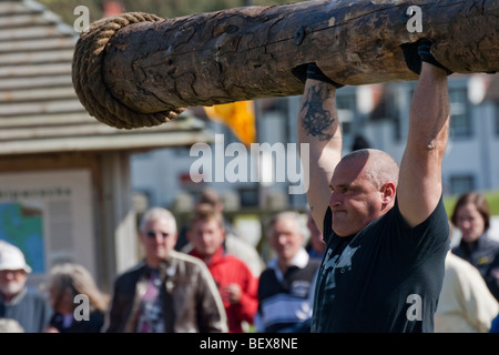 Strongman heben Log bei Galloway-Versammlung Stockfoto