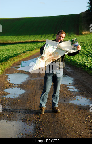 Mann liest Karte bei windigem Wetter. Stockfoto