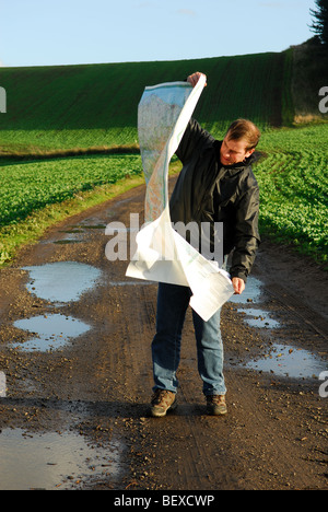 Mann liest Karte bei windigem Wetter. Stockfoto