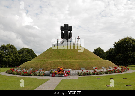 Besucher stehen auf dem zentralen Hügel-Denkmal (ein Massengrab) in La Cambe deutscher Friedhof, Normandie, Frankreich. Stockfoto