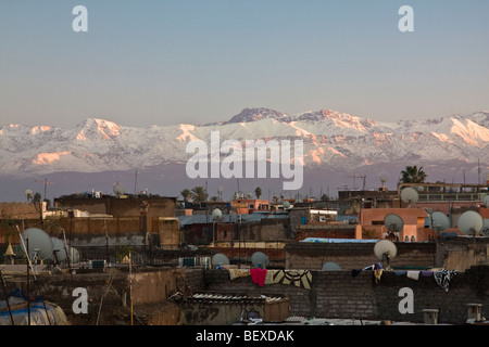 Satellitenschüsseln. Blick von oben auf dem Dach von Marrakesch mit schneebedeckten Atlasgebirge bei Sonnenuntergang im Hintergrund. Marokko Stockfoto