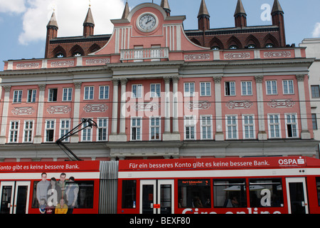 Rathaus in Rostock, Deutschland mit Straßenbahn läuft vorne Stockfoto