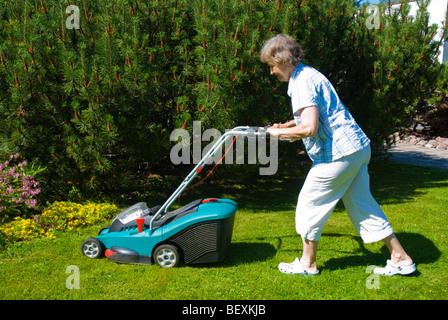 Frau, die den Rasen mähen Stockfoto