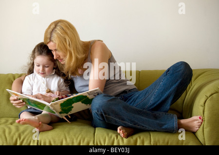 Mutter und Tochter auf der Suche im Bilderbuch Stockfoto