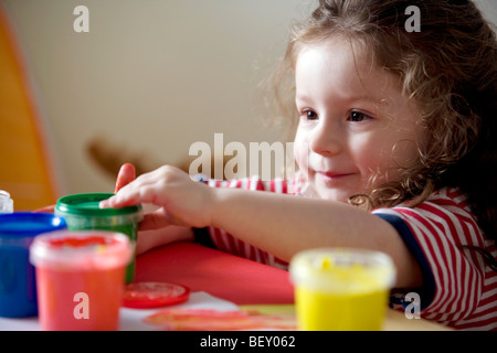 kleine Mädchen spielen mit Farben Stockfoto