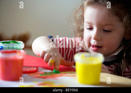 kleine Mädchen spielen mit Farben Stockfoto