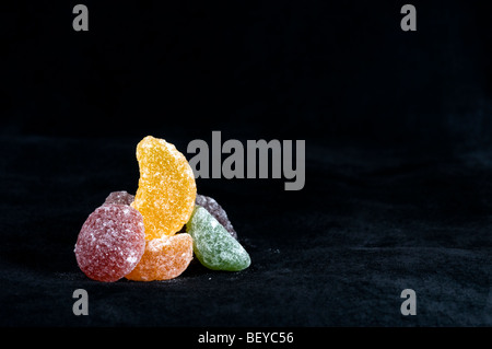 Kleine Haufen Obst Pastille Süßigkeiten auf schwarzem Hintergrund Stockfoto