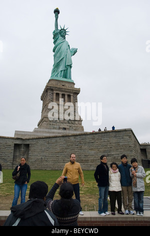 Touristen posieren für Fotos vor der Statue of Liberty, New York City Stockfoto