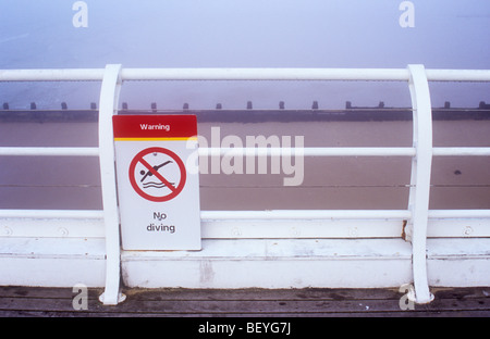 Melden Sie mit ikonische Bild des Tauchers Warnung keine Angabe Tauchen und mit Blick über Geländer der weißen Sandstrand im Nebel Stockfoto