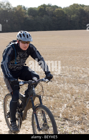 Mountainbiker fährt durch ein Feld. Stockfoto