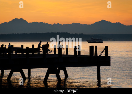 Auf Alki Beach in West Seattle, Washington geht die Sonne über die Olympic Mountains und Bainbridge Island. Stockfoto