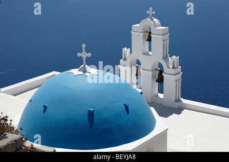 Griechische weiße Kirche mit Glockenturm und blauen Kuppel, mit Blick auf das Meer, Santorini, Kykladen, Griechenland. Stockfoto