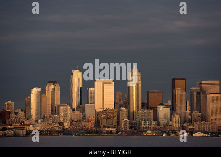 Die Skyline von Seattle bei Sonnenuntergang aufgenommen. Elliott Bay und die Fährschiffe ply den Gewässern zwischen der Innenstadt und Bainbridge Island. Stockfoto