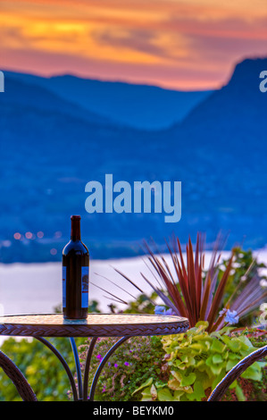 Flasche Wein auf einer Terrassentisch Lang Vineyards, Naramata während des Sonnenuntergangs über Okanagan Lake, Okanagan-Similkameen Region, Okana Stockfoto