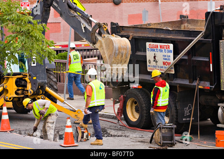 Bauarbeiter graben ein Loch in der Straße. Stockfoto