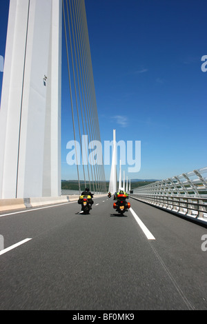 Motorradfahrer, die über das Viadukt von Millau, die höchste Schrägseilbrücke Straßenbrücke in der Welt, Südfrankreich Stockfoto