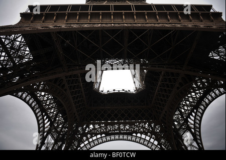 Unter Frankreichs Wahrzeichen, dem Eiffelturm, in der Hauptstadt von Paris, einem bewölkten grauen Himmel blickte. Stockfoto