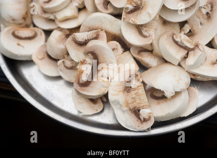 In Scheiben geschnittene Pilze auf einer Aluminiumplatte. Stockfoto