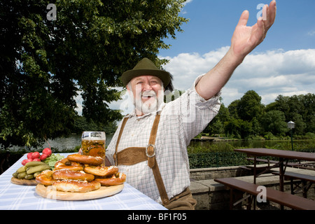 Ein traditionell gekleidet deutscher Mann in einem Biergarten Stockfoto