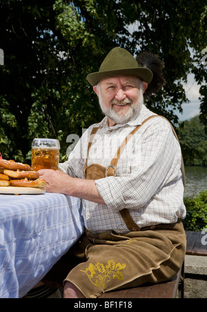 Ein traditionell gekleidet deutscher Mann in einem Biergarten Stockfoto