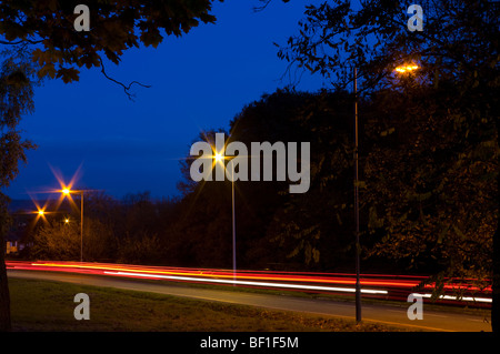 Verkehr-Trails auf einer Landstraße in der Abenddämmerung Stockfoto