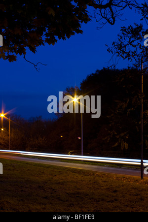 Verkehr-Trails auf einer Landstraße in der Abenddämmerung Stockfoto