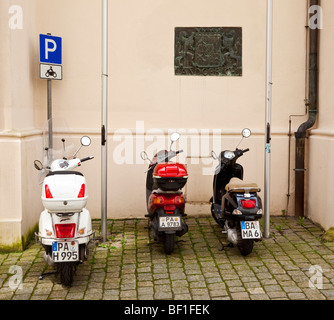 Drei Roller parkten in einer Parkzone Scooter auf einer alten Straße in Deutschland, Europa Stockfoto