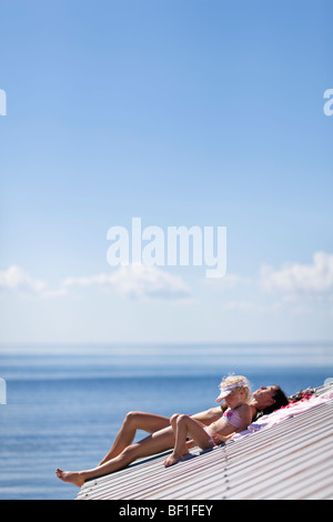 Mutter und Tochter Sonnenbaden auf einem Dach, Schweden. Stockfoto