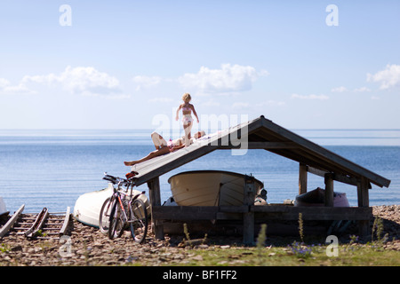 Mutter und Tochter Sonnenbaden auf dem Dach des Schuppen, Schweden. Stockfoto