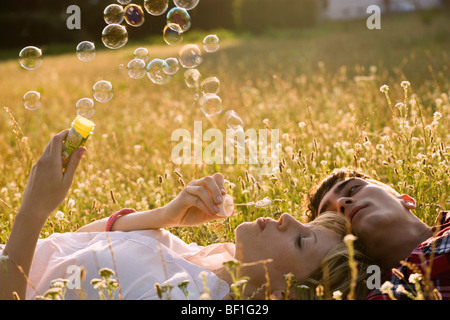 Ein junges Paar in einem Feld Seifenblasen Stockfoto