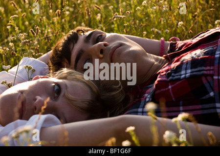 Ein junges Paar liegen auf dem Rücken in einem Feld Stockfoto