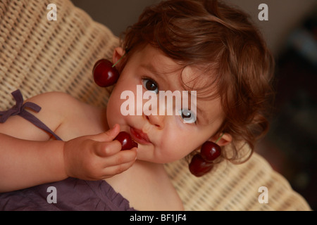 Faustine 18 Monate alt Kirschen essen Stockfoto